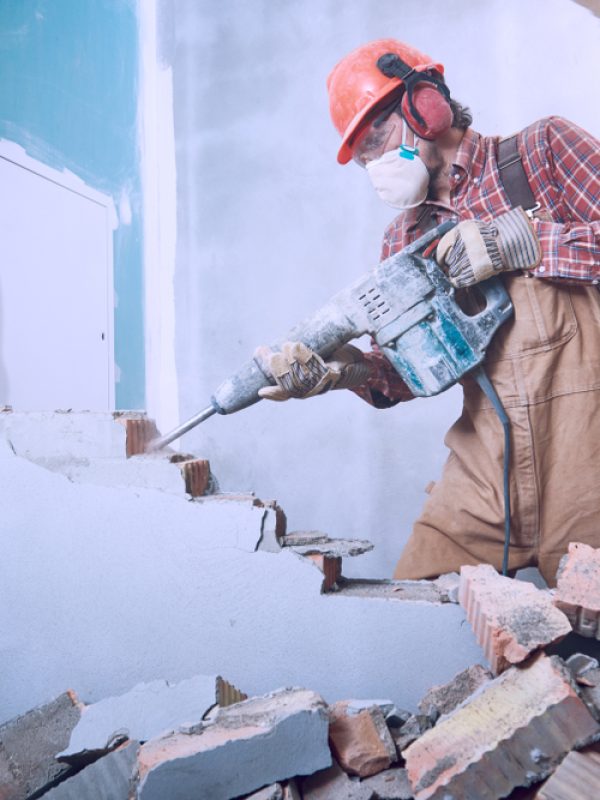 Worker,With,Demolition,Hammer,Breaking,Interior,Wall